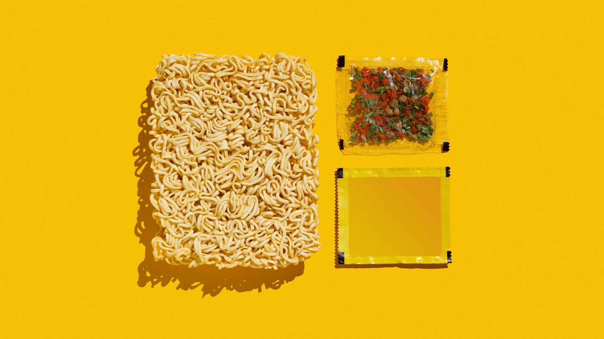 Ein Nudelkuchen der Mie-Noodles, Gewürze in einer durchsichtigen kleinen Tüte