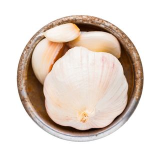 Frische Knoblauchzehen in einer runden Schale von oben sichtbar