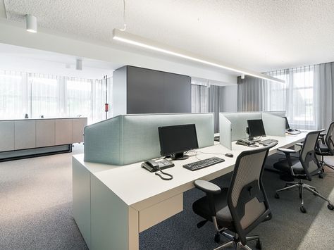 Helles, modernes Büro mit mehreren Arbeitsplätzen, Computern und ergonomischen Stühlen