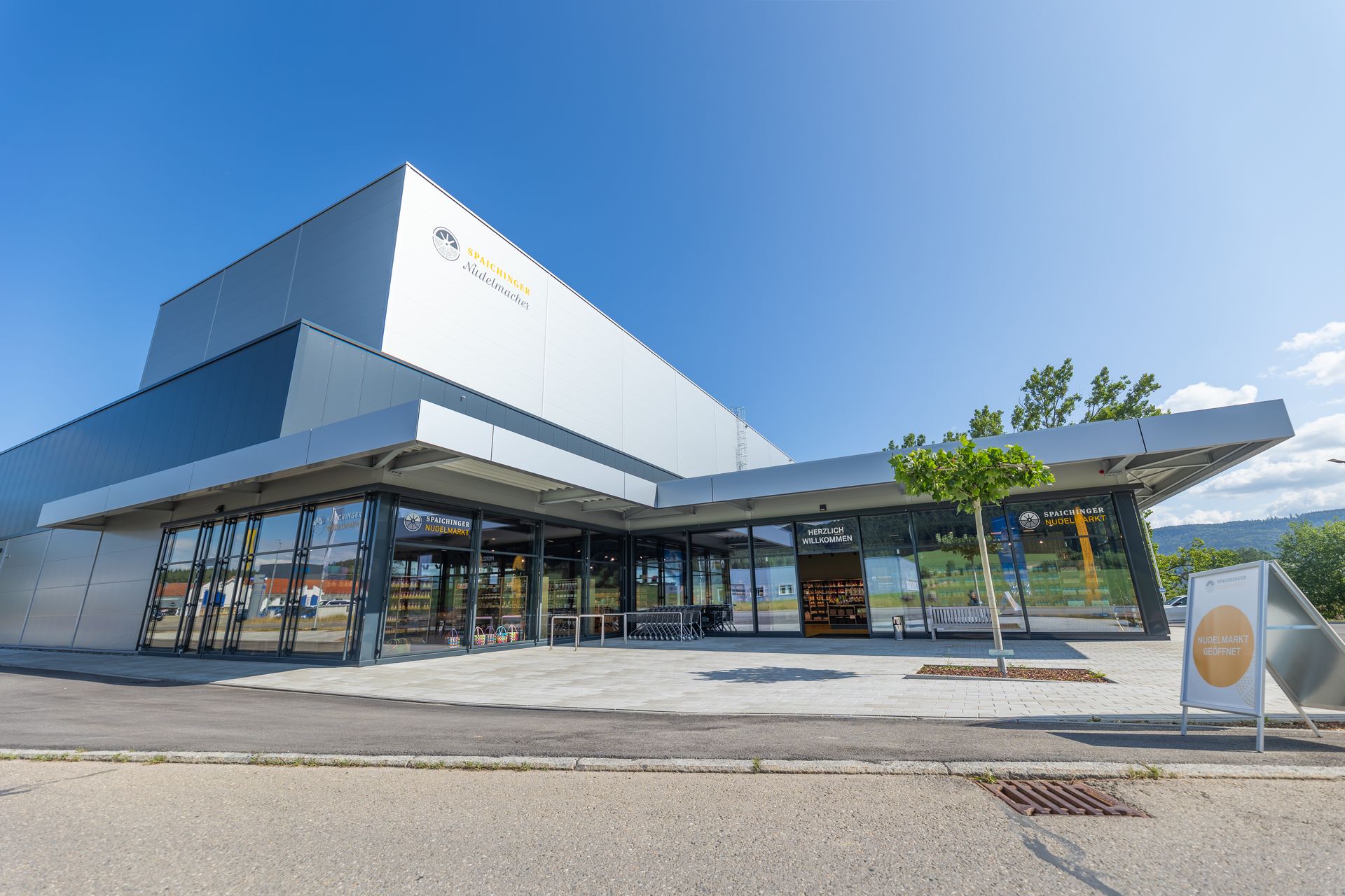 Modern Spaichinger Nudelmacher building with large glass front and pasta market in Spaichingen under a clear sky