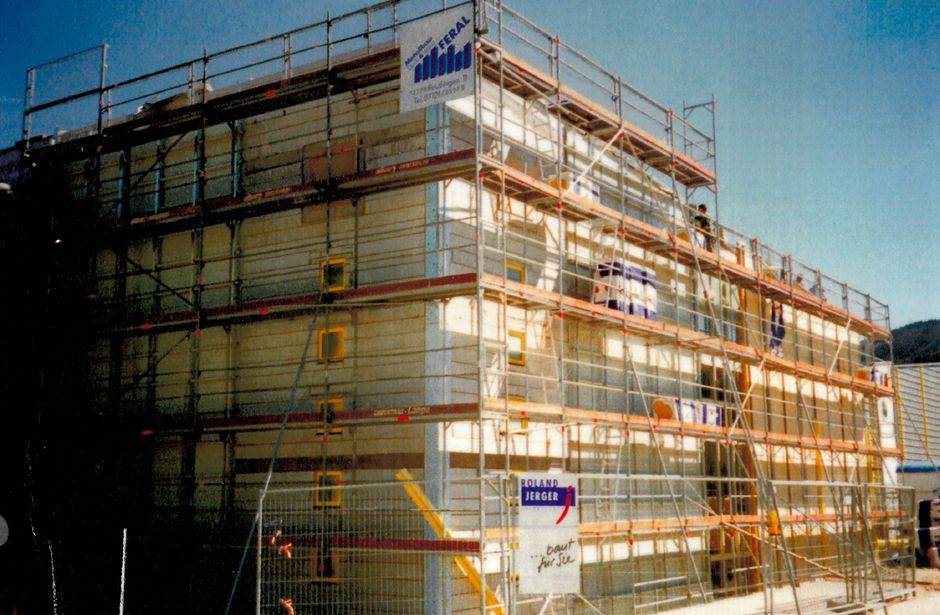 Multi-storey building with scaffolding and sun protection nets during construction work